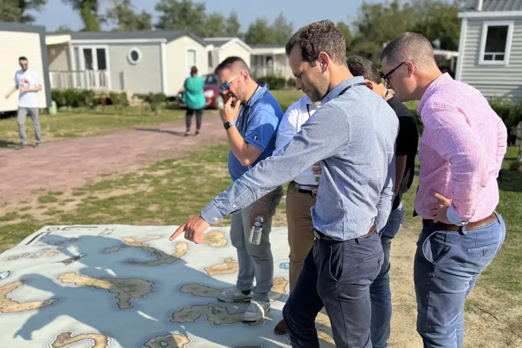 Des joueurs résolvent les énigmes d'un Action Game sur une carte géante au sol