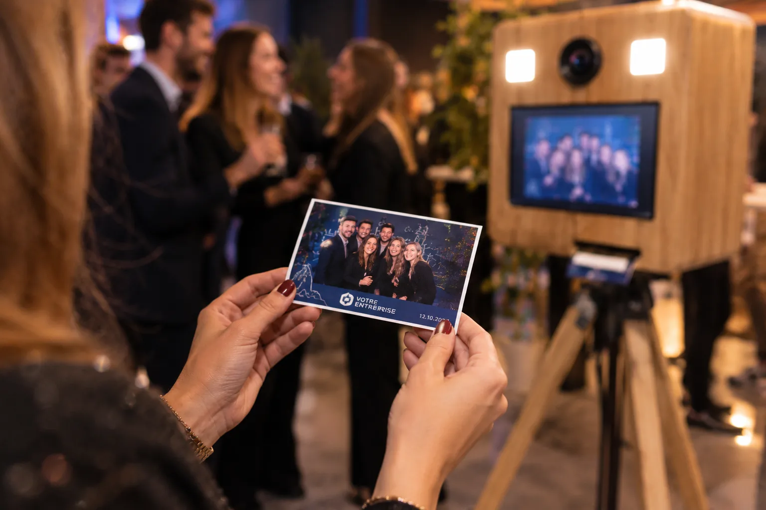 Invitée qui montre son tirage photo 10x15 sorti du photobooth entreprise pendant une soirée en Normandie